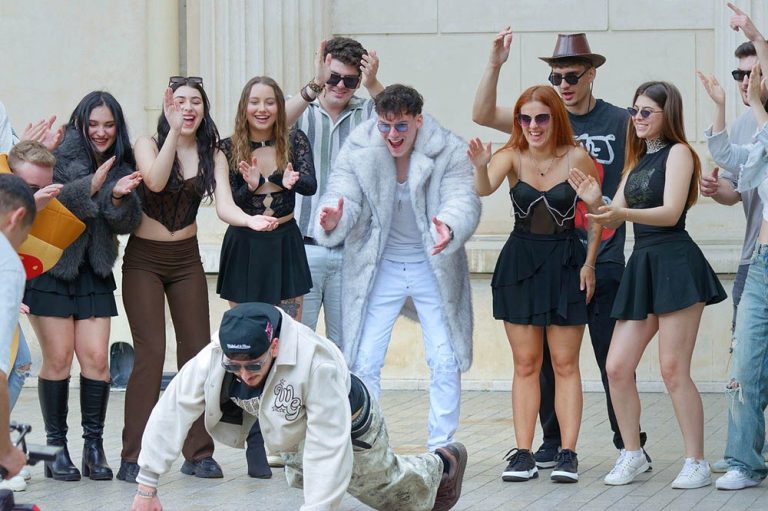 A group of young people, with one breakdancing, the others are cheering