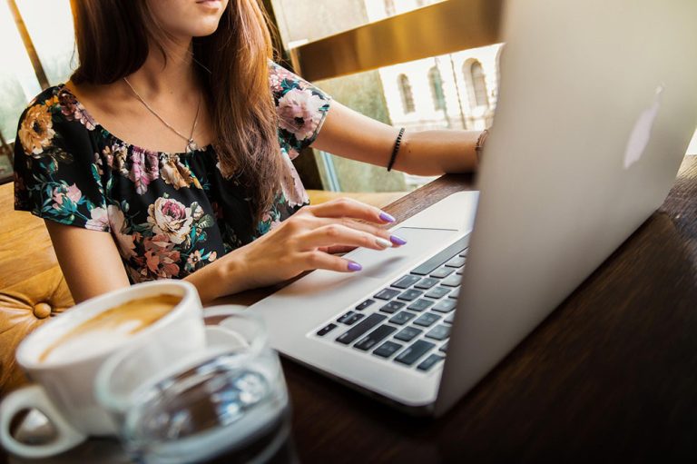 A woman working at a table on her laptop